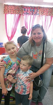 This is a picture of me with my 2 grandkids, Skyler and Nixon at grandparents day at school a couple of years ago.