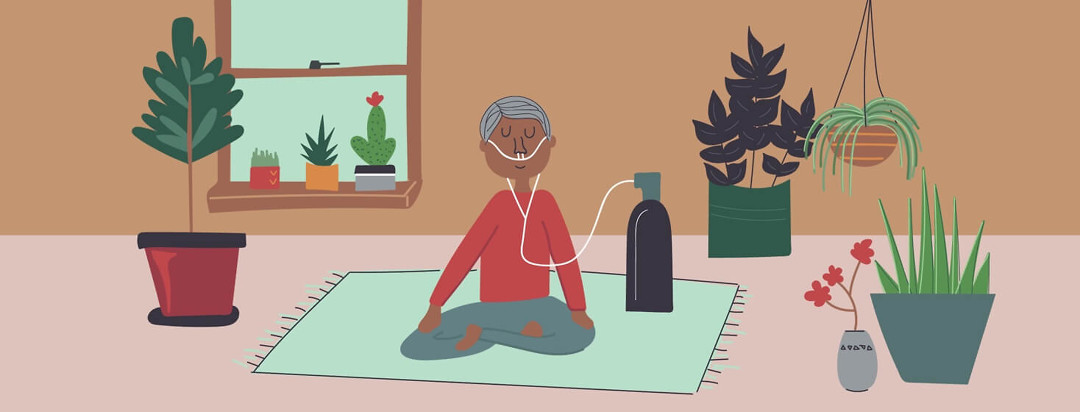 A man meditating with his oxygen tank in a room full of plants