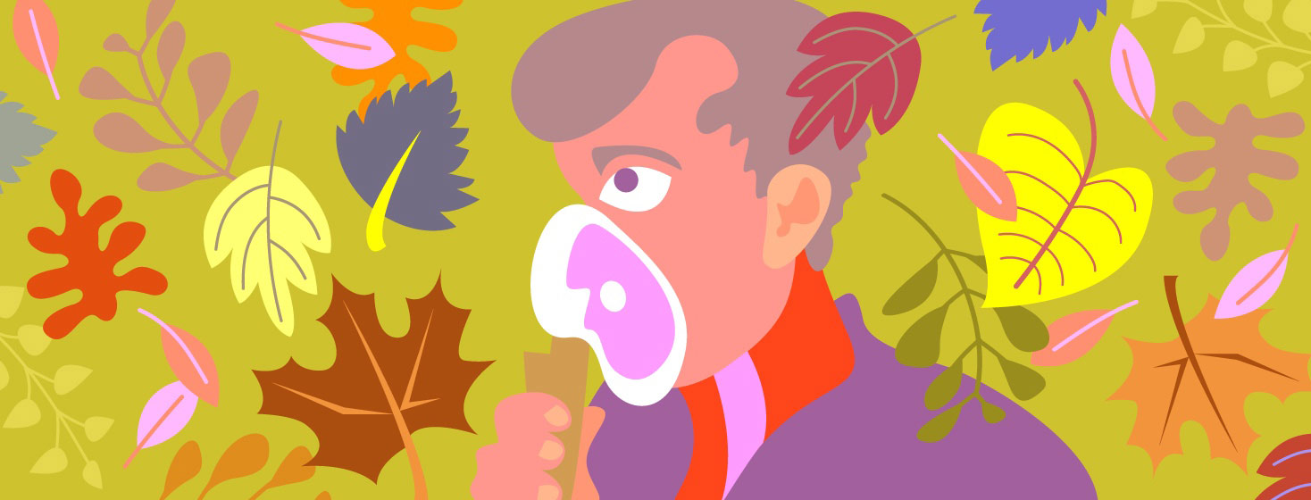 a man uses a nebulizer as colorful autumn leaves swirl around him