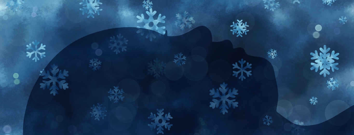 A facial profile silhouetted with snowflakes falling gently down upon it