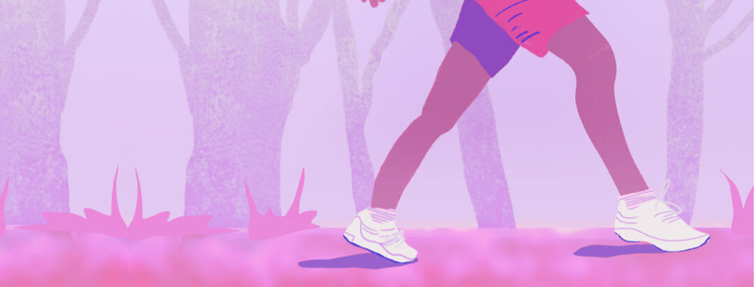 Closeup of a pair of legs in shorts walking down a path in a forest